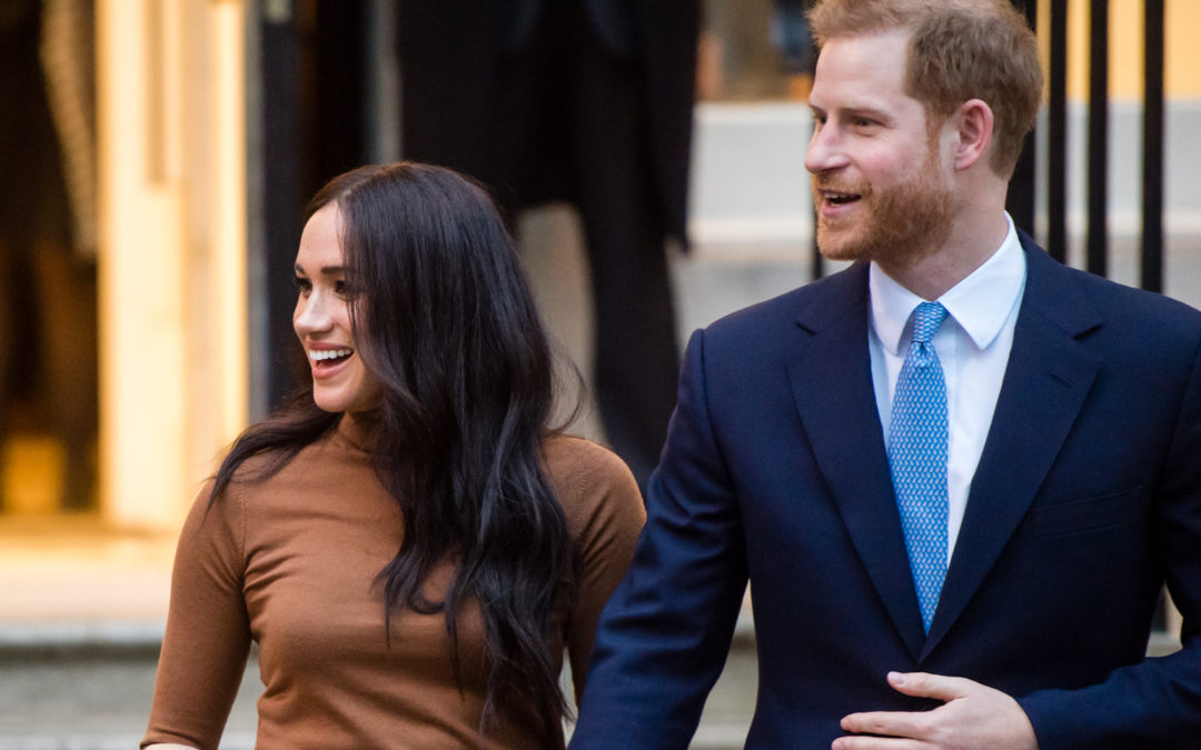 Prince Harry and Meghan Markle wave to fans.